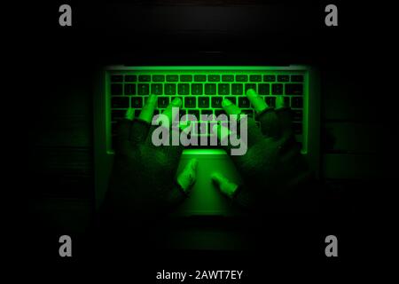 top view of hacker hand typing on laptop keyboard sealing data Stock Photo