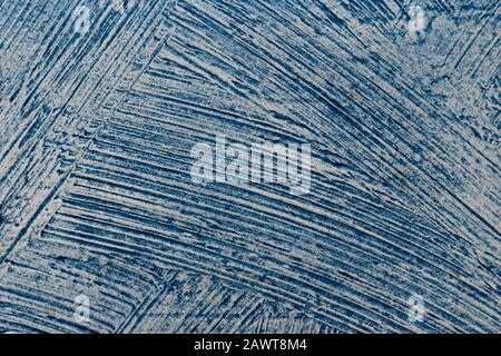 A close-up shot of a distressed relief blue wall painted with wide strokes Stock Photo