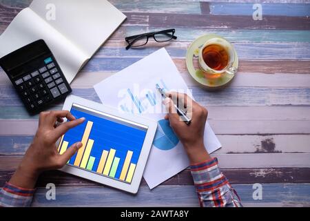 Closeup of man analyzing chart on digital tablet Stock Photo