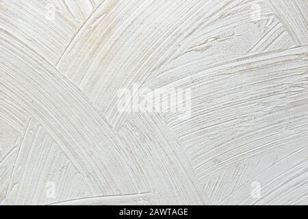 A close-up texture background of a distressed relief white wall painted with wide strokes Stock Photo