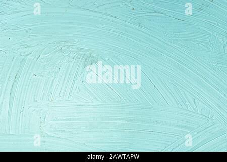 A close-up texture background of a distressed relief light aqua turquoise wall painted with wide strokes Stock Photo