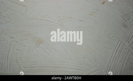 A close-up texture background of a distressed relief dark gray wall painted with wide strokes Stock Photo