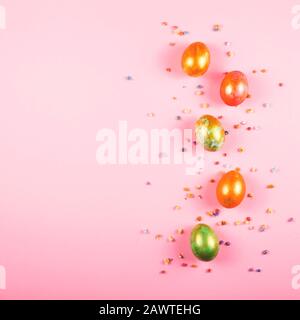 Beautiful painted easter eggs and small flowers on a pink. Easter background with copy space. Stock Photo