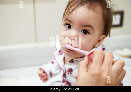 Cute little girl brushing her teeth. Baby health theme Stock Photo