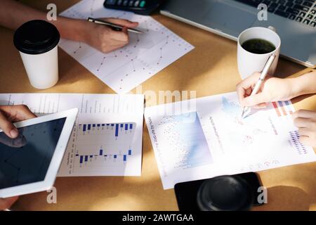 Team of financial managers analyzing charts and diagrams and developing marketing strategy Stock Photo
