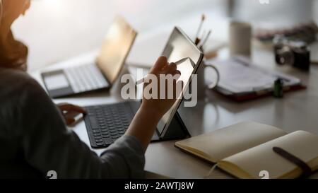 Close up view of female professional designer drawing on digital tablet  in simple co working space Stock Photo