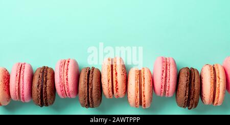 Macarons banner with copy space. Colorful french macarons or macaroons on blue turquoise background. Top view or flat lay Stock Photo