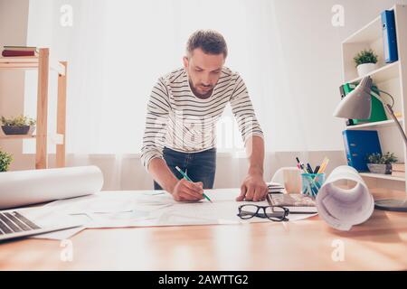 Concentrated young engineer working on plane of new house Stock Photo