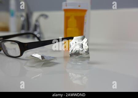 Contact lenses opened and ready to bet put in on sink beside glasses and prescription eye drops Stock Photo