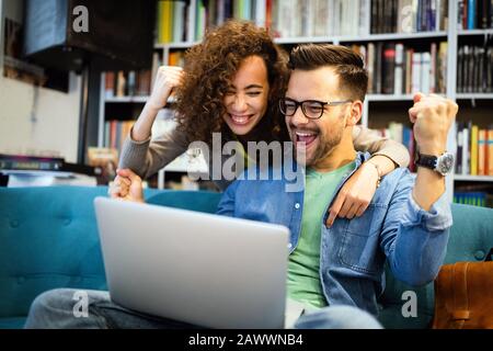 Surprised happy young couple looking at laptop Stock Photo