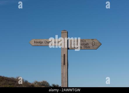 Wooden Sign Post to Trevalga Church and Boscastle on the South West Coast Path with a Bright Blue Sky Background in Rural Cornwall, England, UK Stock Photo