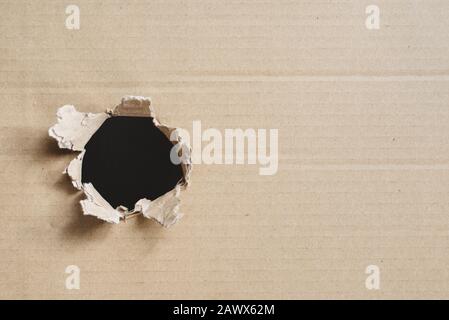 torn corrugated box. Box with hole for copy space. Concept of secret and freight Stock Photo