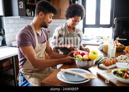 Happy young couple cooking together in the kitchen at home. Stock Photo