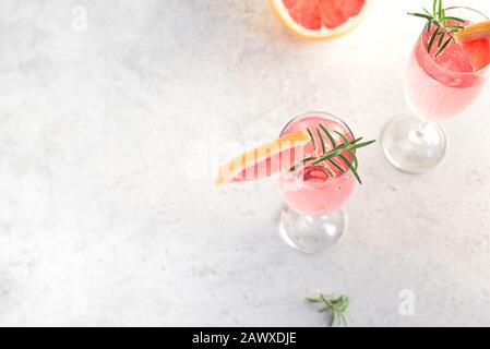Mimosa cocktail with Champagne, Grapefruit and Rosemary in flute glasses, copy space. Mocktail, Mimosa sparkling citrus drink. Stock Photo