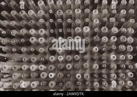 A lot of sewing thread in different colors, sewing thread sorted on a wall Stock Photo