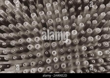 A lot of sewing thread in different colors, sewing thread sorted on a wall Stock Photo