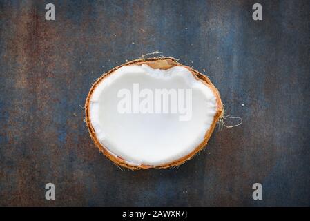 half of coconut fruit for coconut milk on dark table background , top view Stock Photo