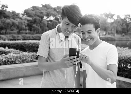 Young Asian man and young Asian teenage boy at the park together Stock Photo