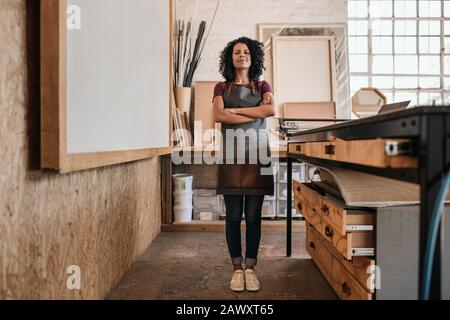 Smiling woman standing in her picture framing studio Stock Photo