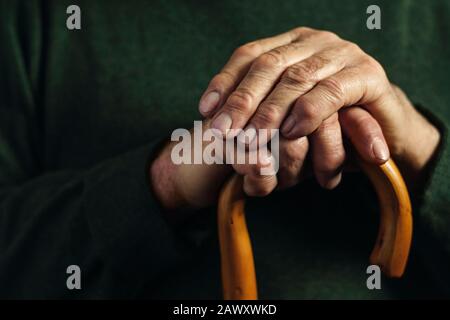 Hands of a senior man clasping a cane Stock Photo