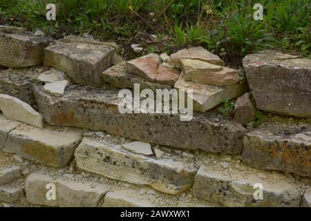 close-up view of lost place rock wall with broken tiles, abandoned scruffy and broken rock wall Stock Photo