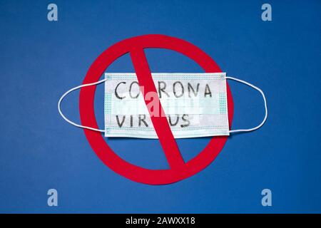 Text Coronavirus on medical masks with red stop sign on blue background. Wuhan Stop Coronavirus, 2019-nCoV. concept top view. Stock Photo