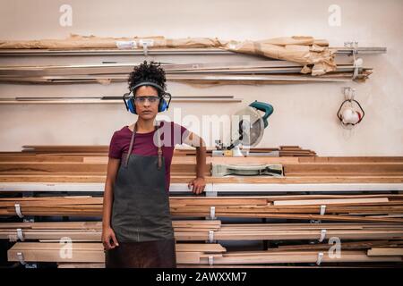 Female artsian standing in her frame making workshop Stock Photo