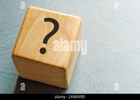 Wooden toy block with printed question mark Stock Photo