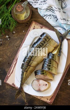 Mediterranean food, seafood. Tasty Appetizing smoked mackerel with spices on dark rustic wooden table. Top view flat lay background. Stock Photo