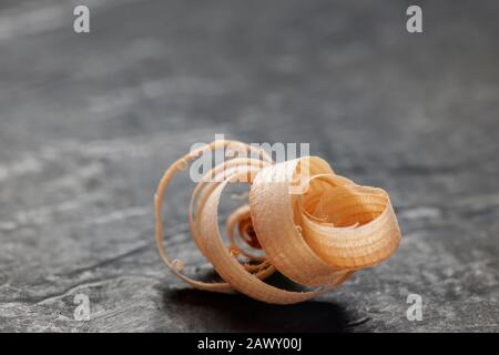 Close-up of a single planer chip lying on a slate board. Stock Photo