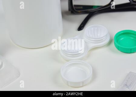 Contact lens case flat lay up close with other eye wear products including glasses and solution Stock Photo