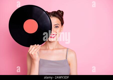 Portrait of positive cheerful girl hide her face with circle turntable vinyl disc want listen retro music hits wear good look clothes isolated over Stock Photo