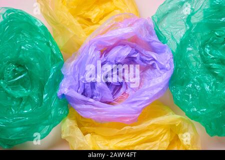 Horizontal from above flat lay shot of empty multi-coloured plastic garbage bags on neutral background Stock Photo