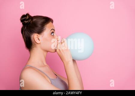 Profile side photo of astonished girl blowing small white air baloon look copy space impressed wear casual style clothes isolated over pink color Stock Photo