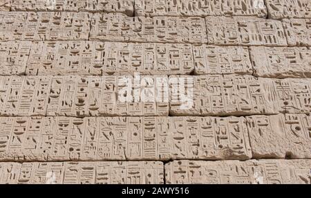 Hieroglypic carvings on wall at the ancient egyptian temple of Medinat Habu in Luxor Stock Photo