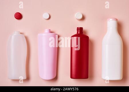 Horizontal from above flat lay conceptual image of plastic bottles with tops on pale pink background Stock Photo