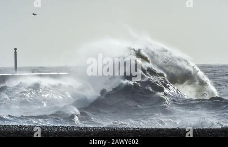 Shoreham UK 10th February 2020 - Waves crash in at the entrance of Shoreham harbour in Sussex as the tail end of Storm Ciara gradually blows through Britain after battering most of the country over the weekend : Credit Simon Dack / Alamy Live News Stock Photo