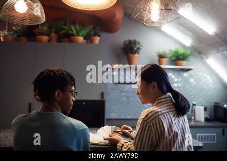 Back view portrait of two contemporary designers discussing color swatches in kitchen interior Stock Photo