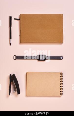 Vertical from above minimalistic modern office flat lay composition shot, pale pink background Stock Photo