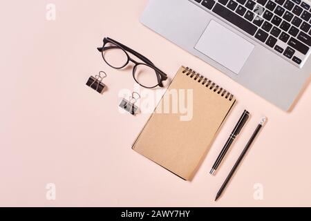 Stylish modern office desktop flatlay composition on pale pink background, horizontal from above shot Stock Photo