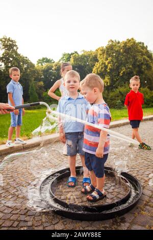 Happy boys standing in big soap bubble together Stock Photo