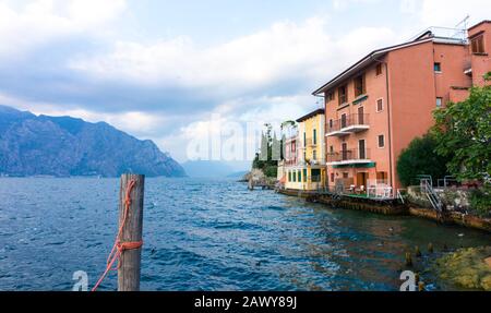 Charming view of an old European city above a mountain lake. Postcard with a view from the pier on the embankment of the Italian village. Stock Photo