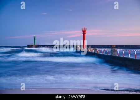 beautiful sunset with lighthouse and blue clouds over the sea Stock Photo