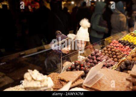 Happy children choosing sweets in christmas market Stock Photo
