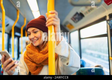 Young woman texting with smart phone on bus Stock Photo