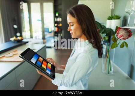 Female interior designer looking at digital color swatches on digital tablet Stock Photo