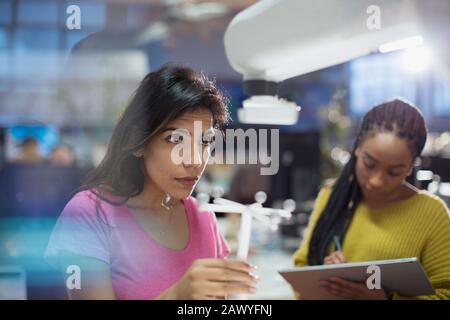 Female engineers testing robotic arm in office Stock Photo