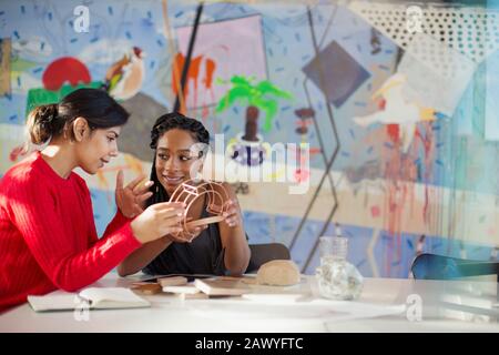 Female engineers examining prototype in creative conference room Stock Photo