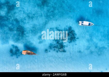 Aerial view of the white boat in the clear blue water at sunset Stock Photo