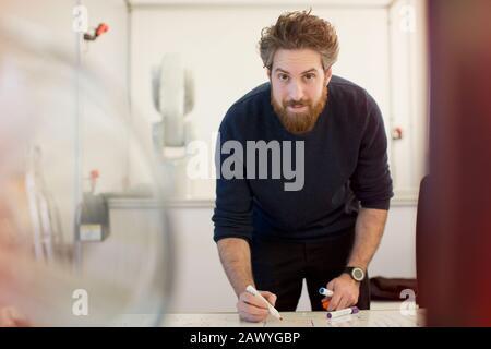 Portrait confident male engineer planning at whiteboard in office Stock Photo